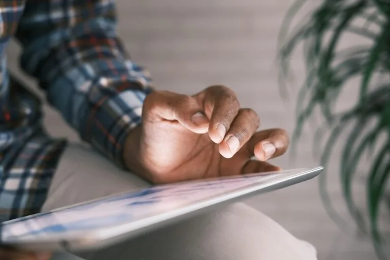 person using tablet on couch
